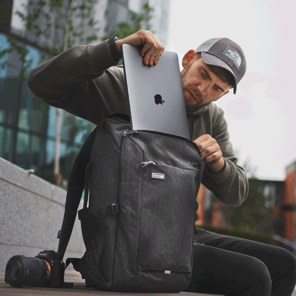 Man pulling laptop out of a Backstory Backpack