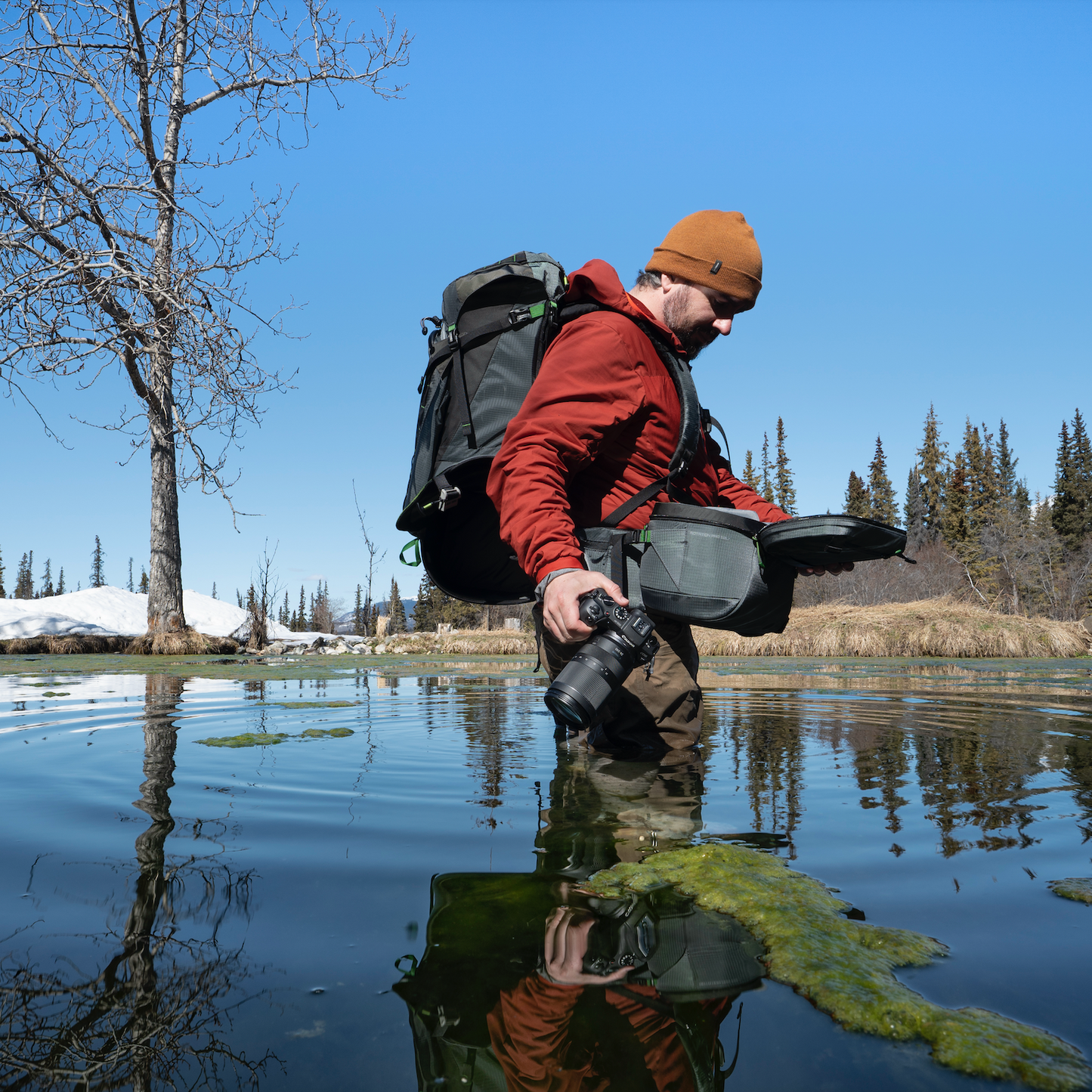 Photographer knee-deep in a pond